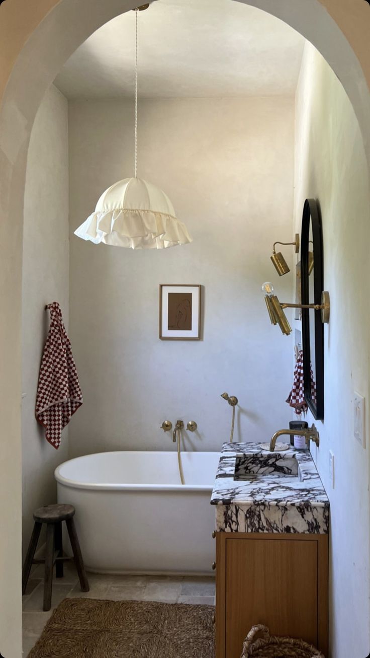 a bathroom with an arched doorway leading to the bathtub and sink area is shown