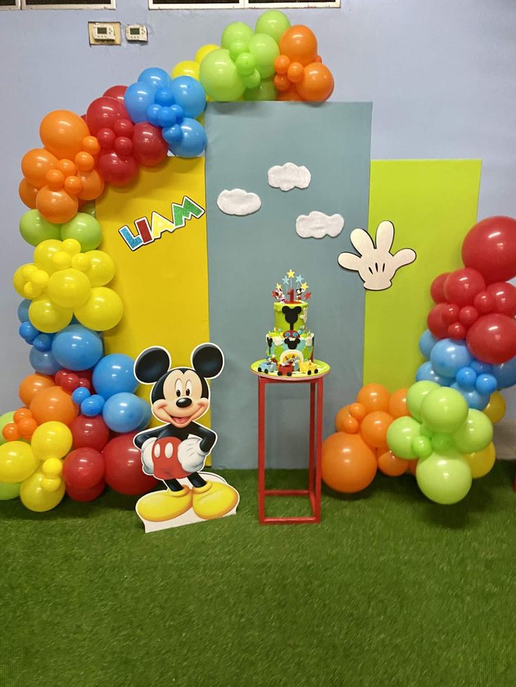 a mickey mouse birthday party with balloons and decorations