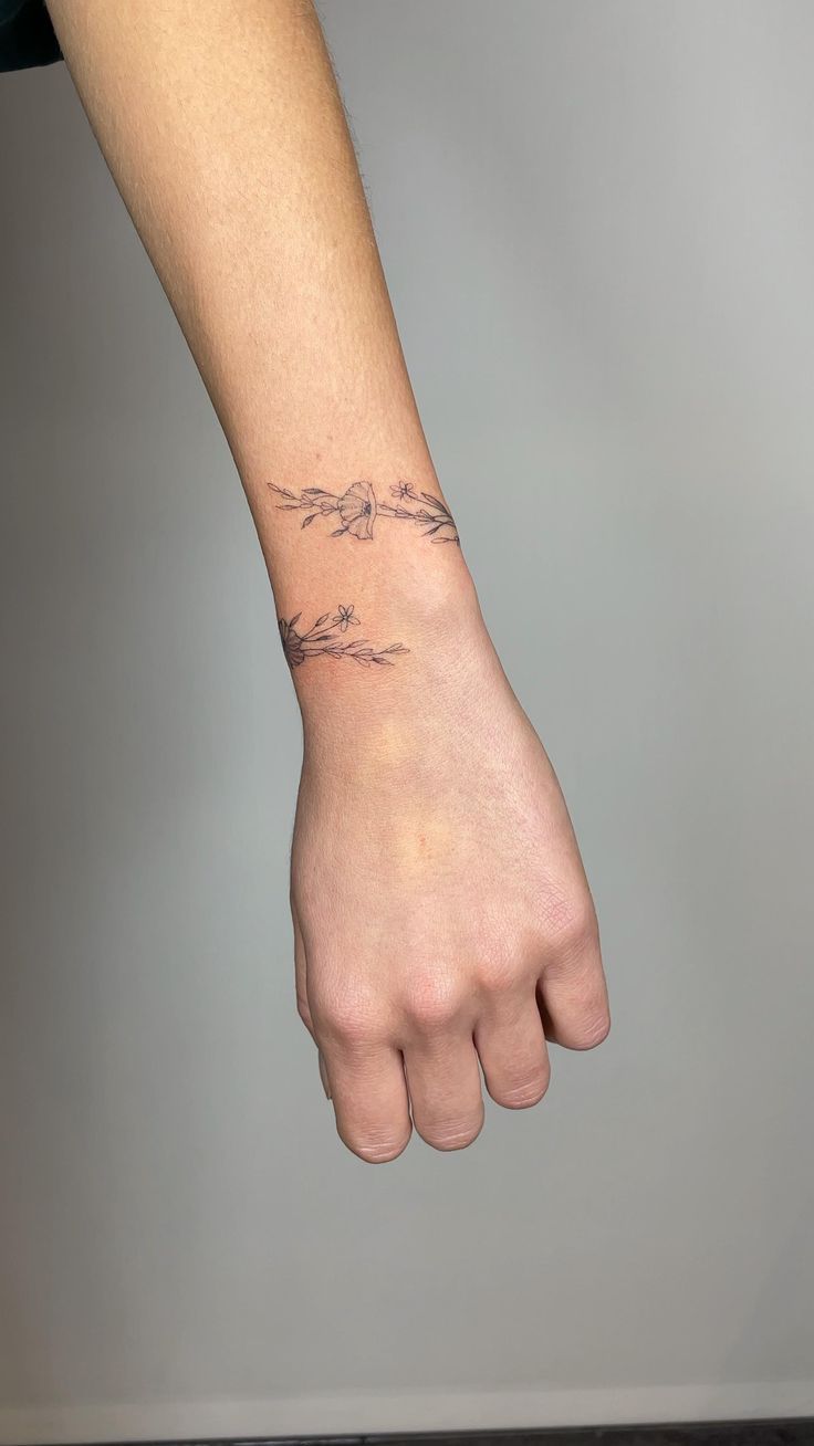 a person's hand with a tattoo on their left wrist and the other arm