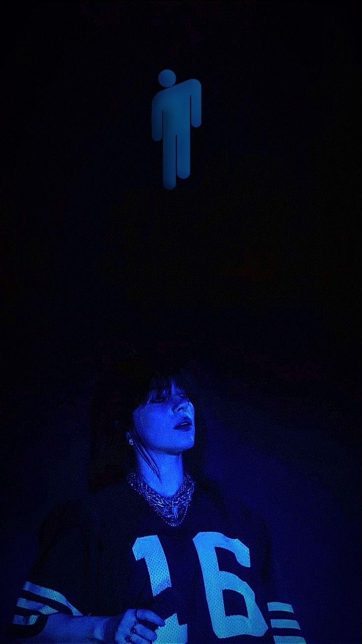 a woman sitting in the dark with her hands on her hips, looking up at an illuminated sign above her head