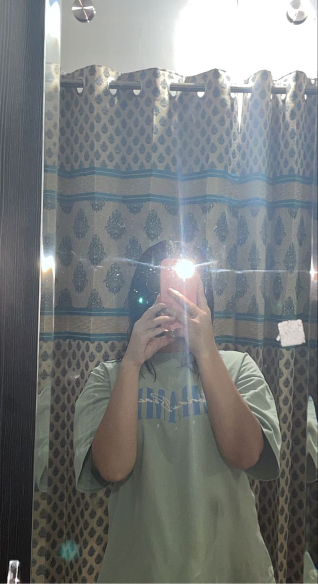 a man taking a selfie in front of a bathroom mirror with his cell phone