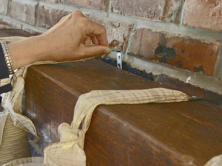 a person is holding something in their hand near a brick wall