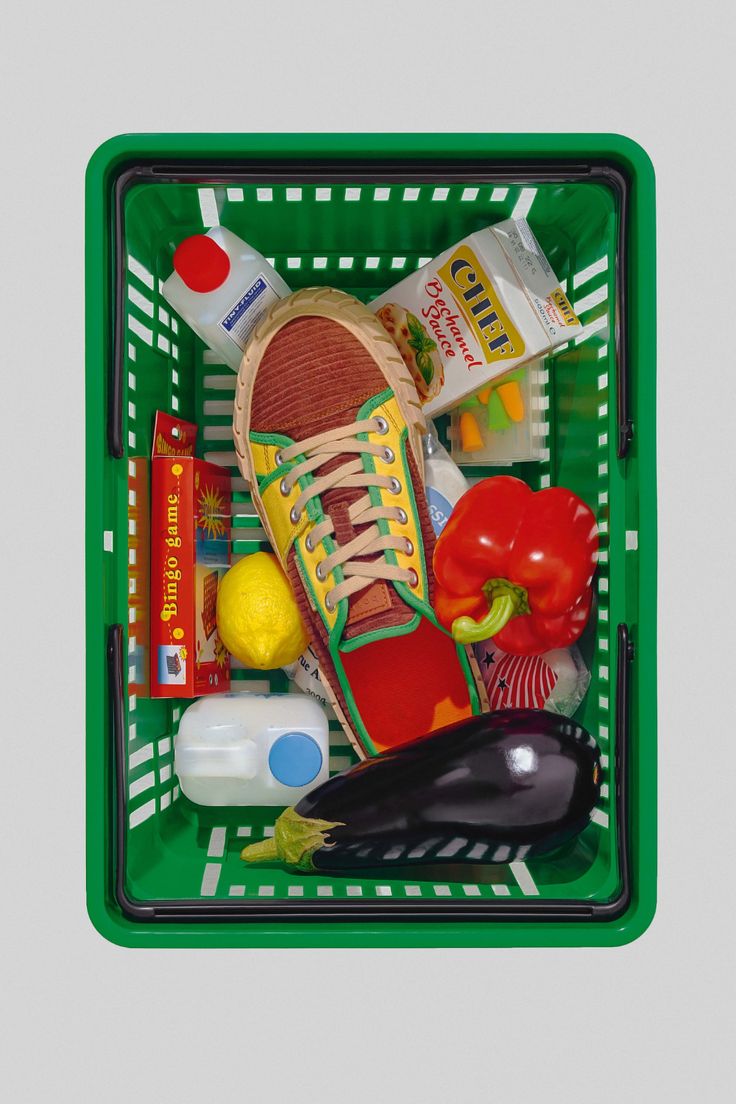 a green shopping basket filled with food and condiments