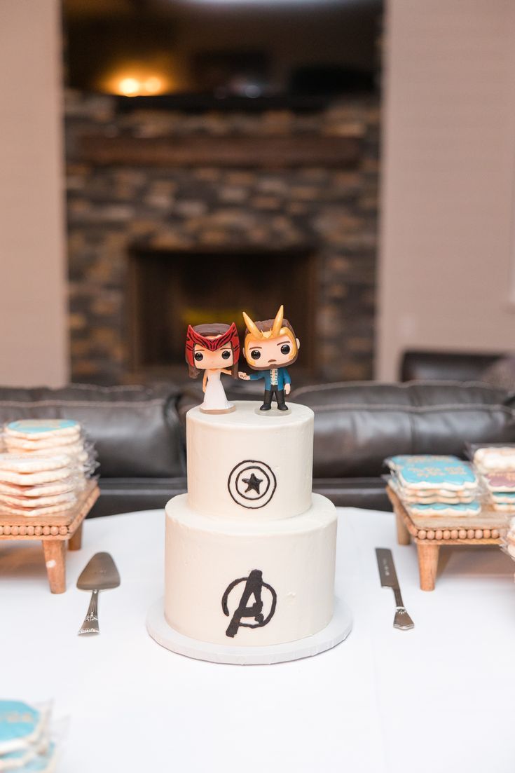 two figurines on top of a wedding cake in front of a fire place