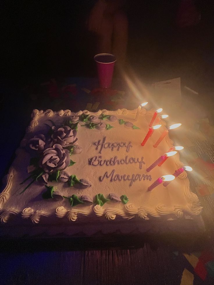 a birthday cake with lit candles on it