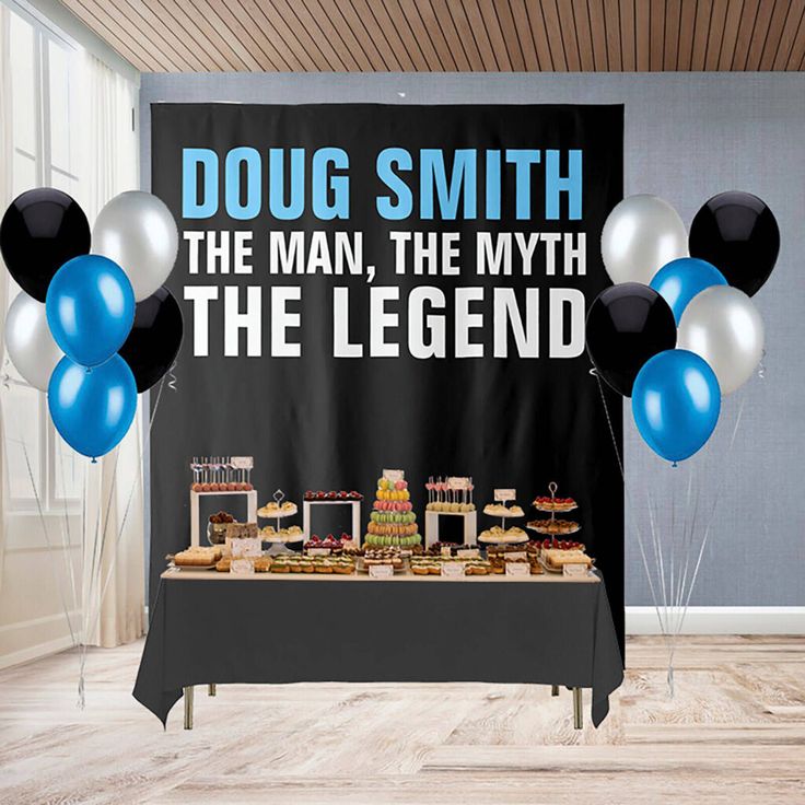 a table topped with cake and balloons next to a sign that says doug smith the man, the myth