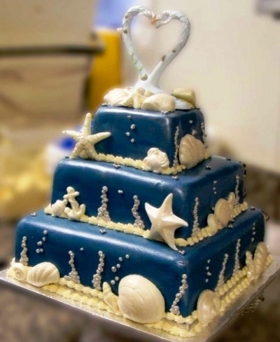 a three tiered blue cake with white decorations