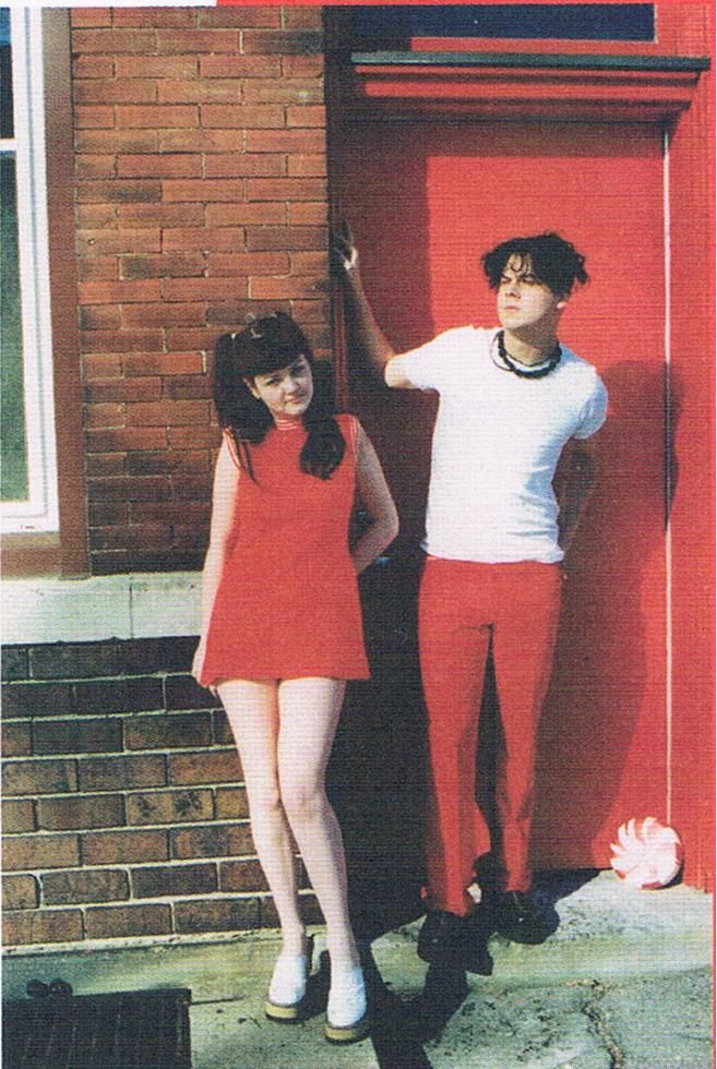 two people standing in front of a red door