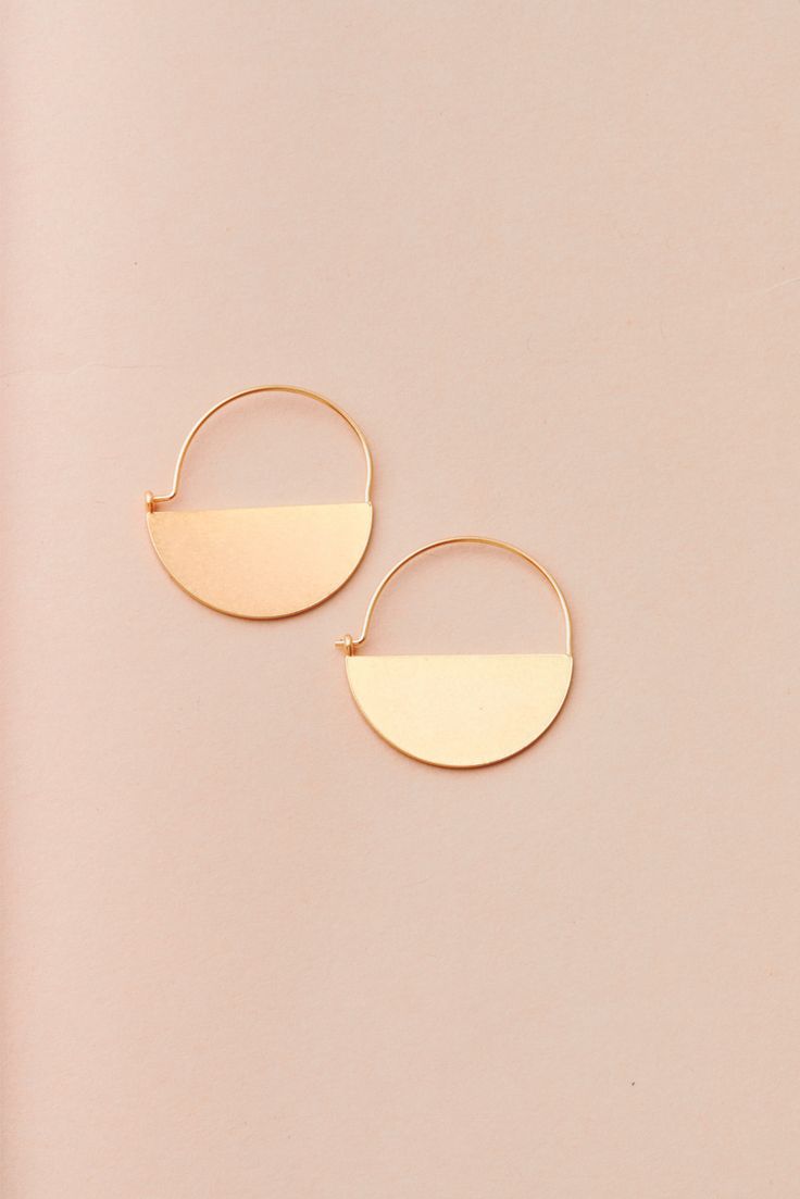 These earrings offer the perfect minimalistic design made with luxe materials. The Lunar Hoop Earring is refined, lightweight, and will elevate any look instantly. Wear on special occasions like date night and weddings or wear while doing day to day errands. Made with high-quality 18k gold vermeil 1.125" wide x 1.5" drop Brass body with gold vermeil wire Nickel and Cadmium free Hypoallergenic Modern Rose Gold Hoop Earrings For Everyday Wear, Modern Rose Gold Tarnish Resistant Hoop Earrings, Modern Rose Gold Tarnish-resistant Hoop Earrings, Modern Tarnish-resistant Rose Gold Hoop Earrings, Modern Small Hoop Rose Gold Earrings, Minimalist 14k Gold Filled Circle Earrings, Chic Rose Gold Hoop Earrings For Everyday, Minimalist Rose Gold Tarnish-resistant Hoop Earrings, Modern Rose Gold Small Hoop Earrings