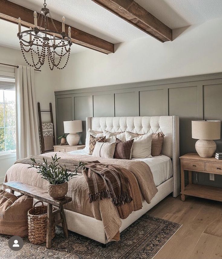 a large bed sitting under a chandelier in a bedroom next to a window