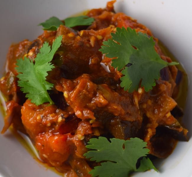 a white bowl filled with food and garnished with cilantro leaves on top