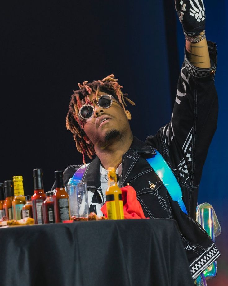 a man with sunglasses on sitting at a table full of bottles and condiments