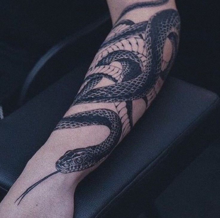 a person's arm with a snake tattoo on it