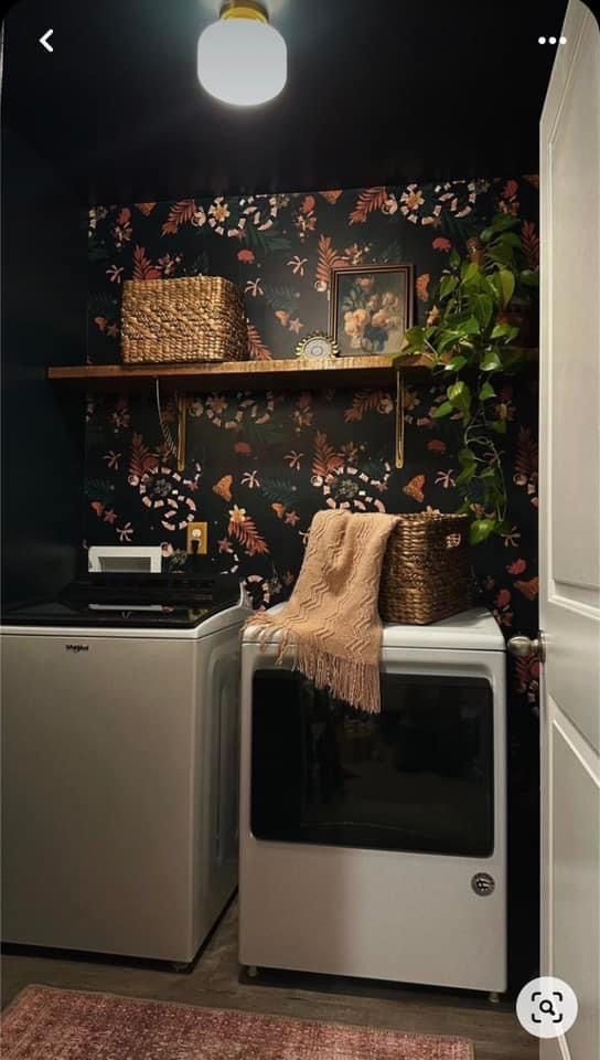 a washer and dryer in a room with floral wallpaper on the walls