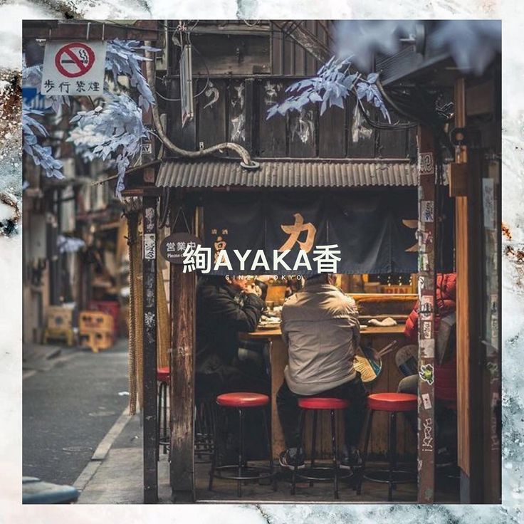 a man sitting at a table in front of a store