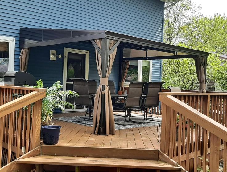 a patio covered with a gazebo next to a blue house