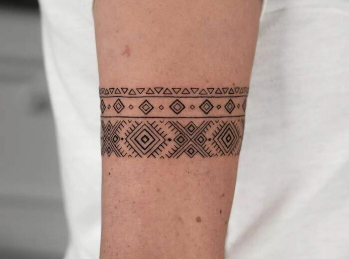 a person with a tattoo on their arm that has an arrow in the middle of it