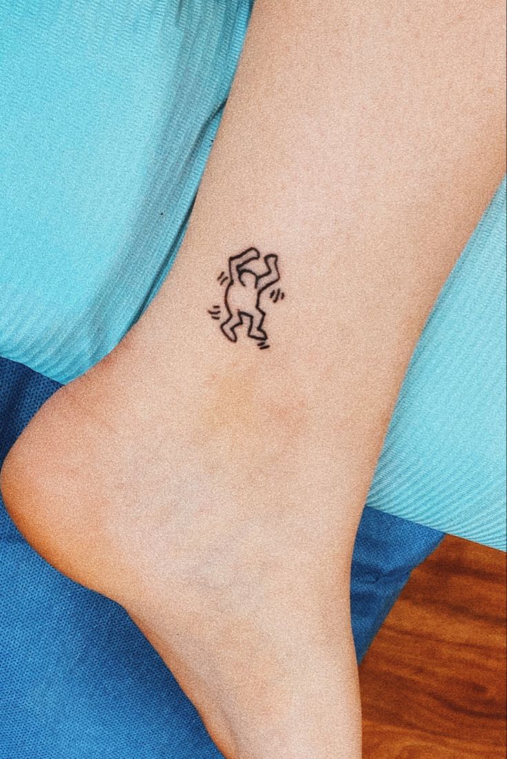 a woman's foot with a small tattoo design on the left side of her ankle