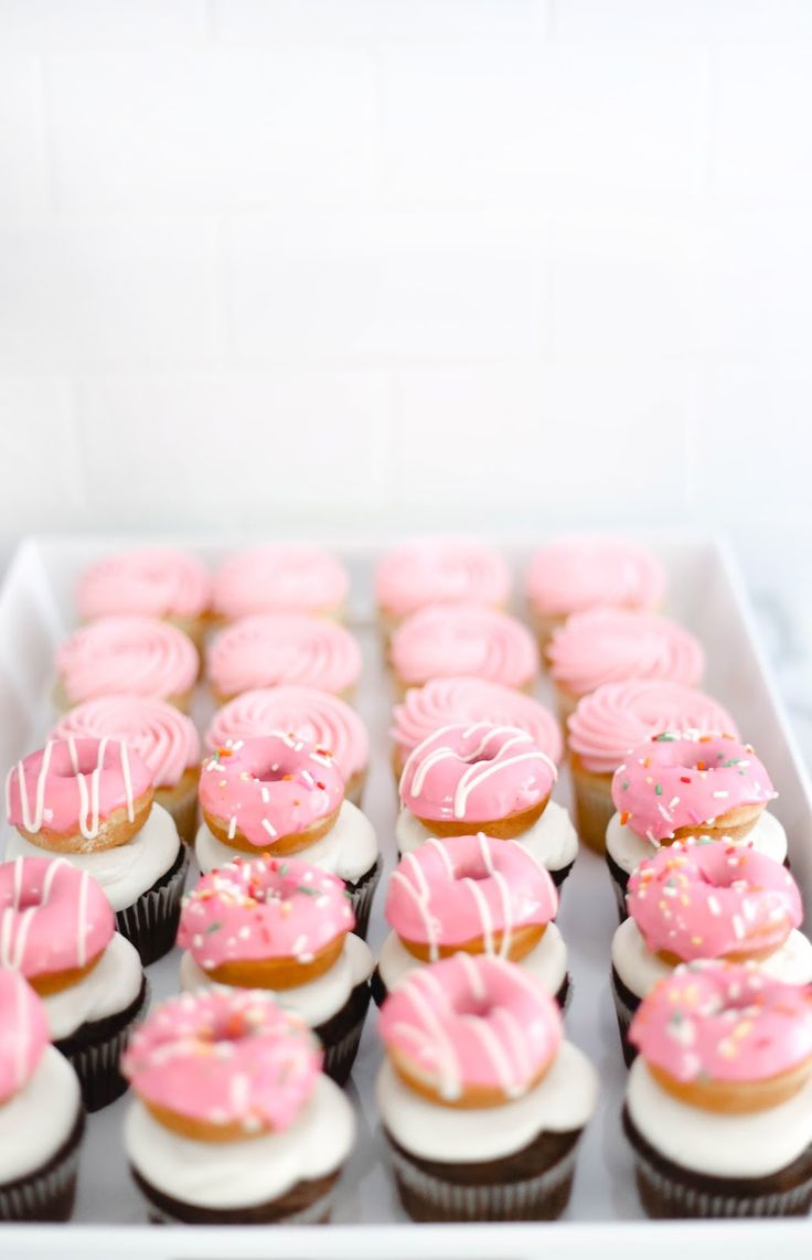 cupcakes with pink frosting and sprinkles in a white box