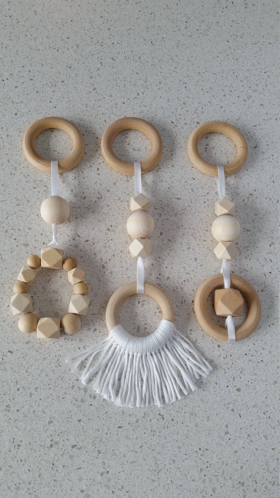 four wooden teeth and rings with tassels hanging from the ends on a wall