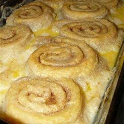 a pan filled with cinnamon rolls sitting on top of a stove