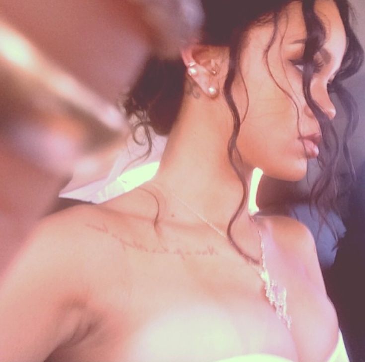 a close up of a person wearing a dress and necklace with hair blowing in the wind