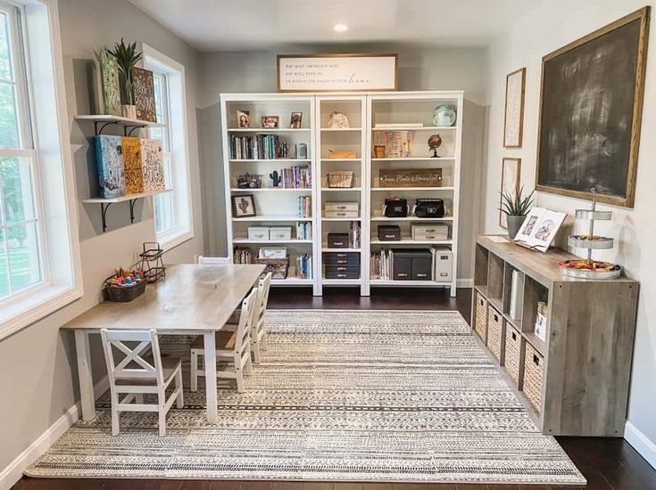 a room with a table, chairs and bookshelves