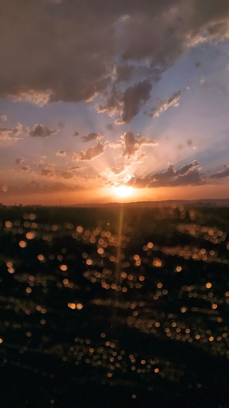 the sun is setting over an open field