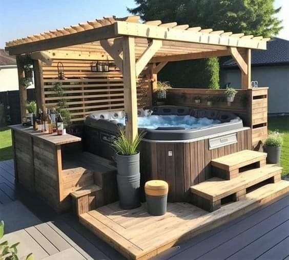 a hot tub sitting on top of a wooden deck next to a green lawn area