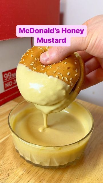 someone is dipping some kind of food into a small glass bowl on a wooden table