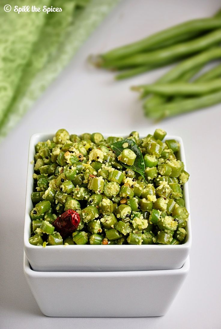 a white bowl filled with green vegetables on top of a table