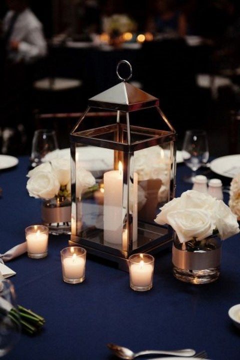 the centerpieces are filled with white flowers and candles