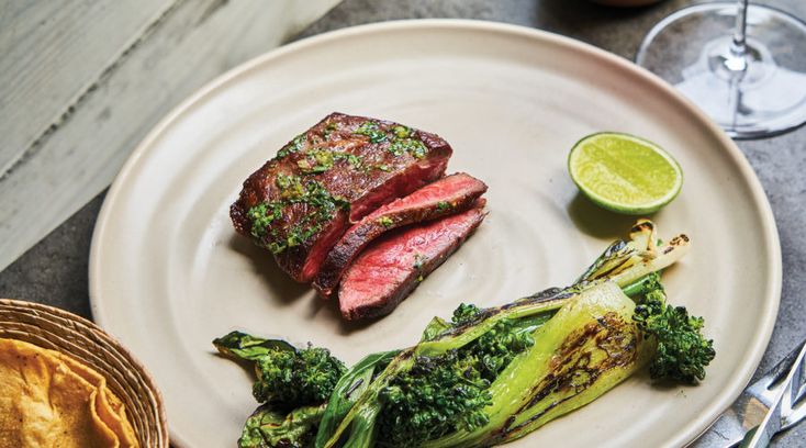 steak and broccoli on a white plate with silverware