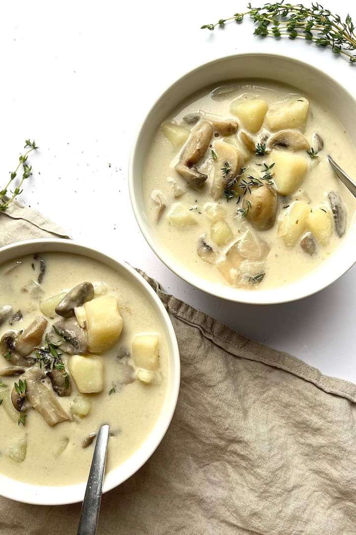 two bowls of mushroom potato soup on a table