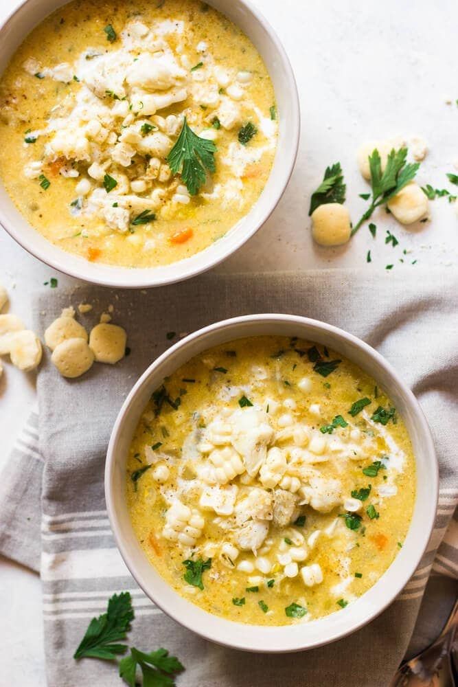 two bowls filled with soup and garnished with parsley