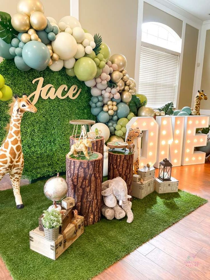 a giraffe is standing in front of a backdrop with balloons and letters that spell out the word race