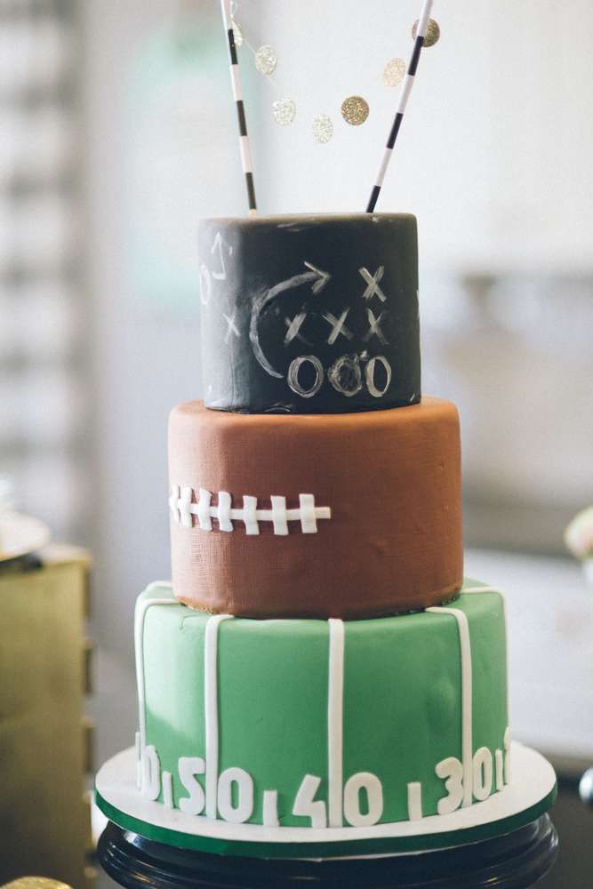 a three tiered cake decorated with footballs and sparklers