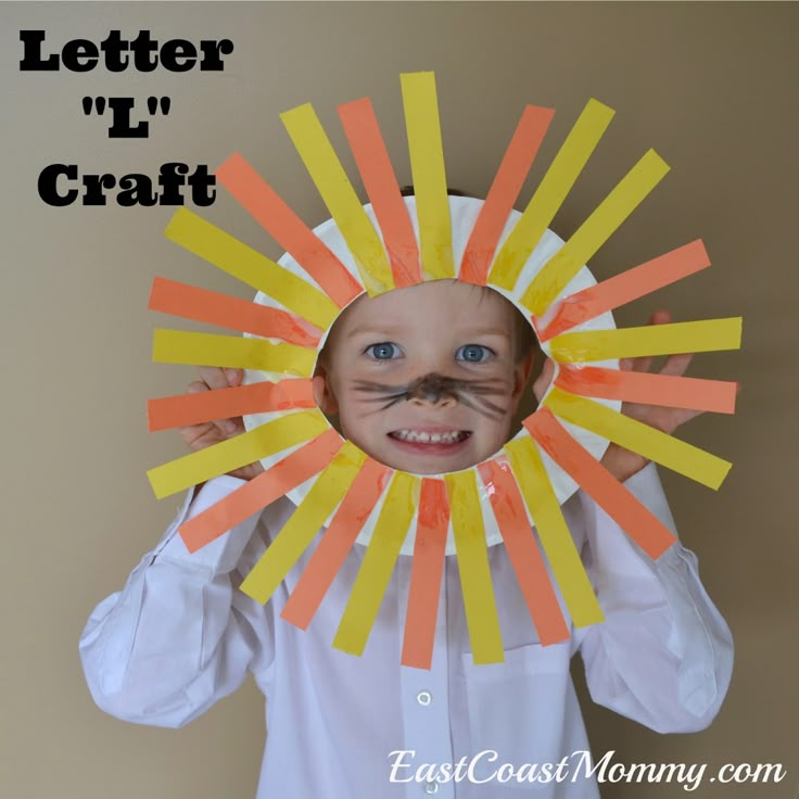 a young child wearing a paper sunburst with the words letter l'craft on it