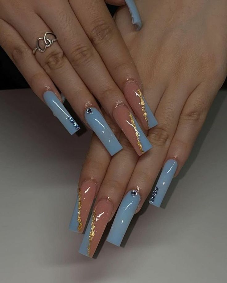 two hands with blue and gold nail designs on them