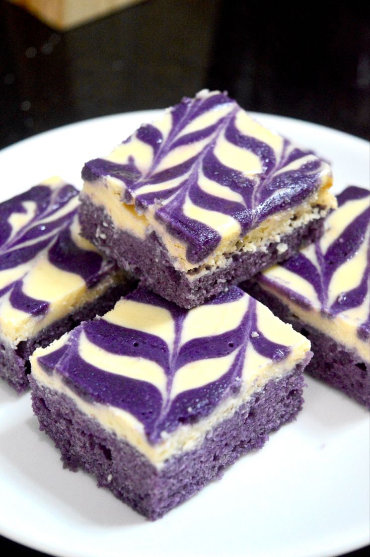 four pieces of purple and white cake on a plate