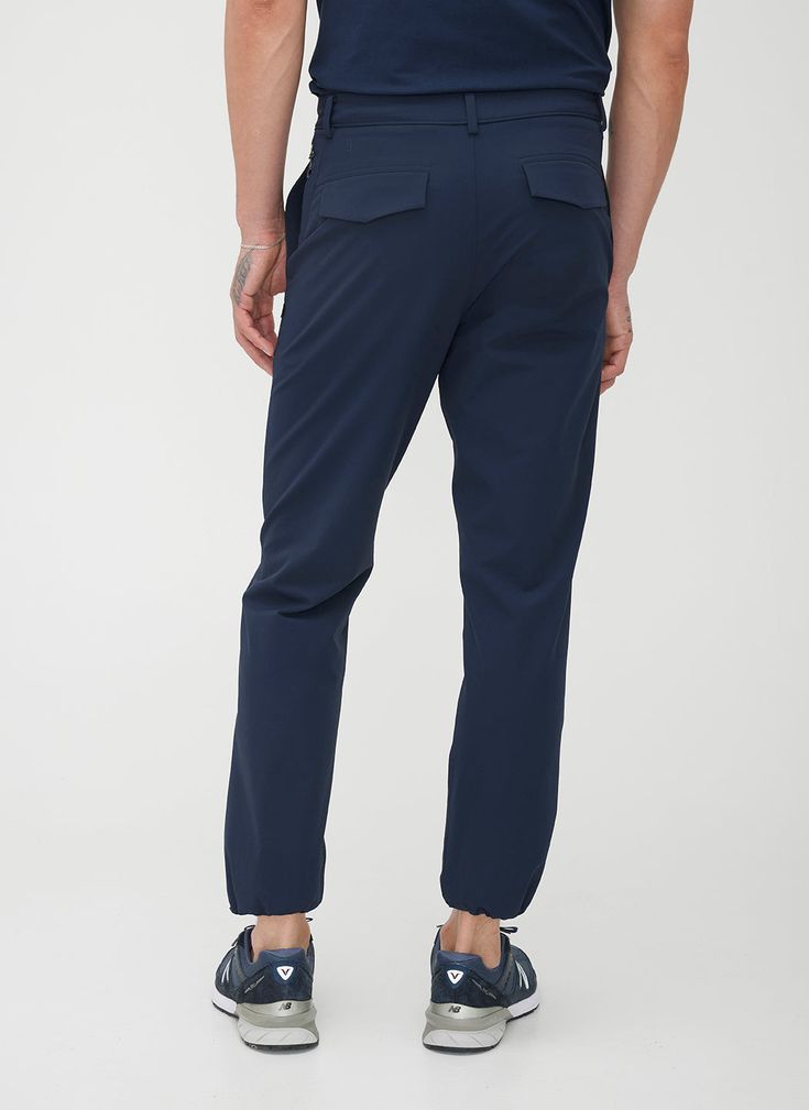 A smart looking trouser that performs as well as you do, both at work and at play. Water-resistant fabric, made from recycled materials, brings innovation, while four-way stretch, articulated knees, and a stretch waistband ensure supreme comfort. Technical details like a reflective side zip pocket and a cord at the ankle for adjusting the fit make these pants your new go-to. Versatile Tapered Leg Dress Pants With 4-way Stretch, Versatile 4-way Stretch Tapered Leg Dress Pants, Ankle-length Dress Pants With Elastic Waistband And 4-way Stretch, Workwear Bottoms With Functional Pockets, Functional Pockets Long Work Pants, Versatile 4-way Stretch Work Pants, 4-way Stretch Dress Pants With Elastic Waistband For Work, Solid Color Workwear Pants With Functional Pockets, Solid Pants With Functional Pockets For Work