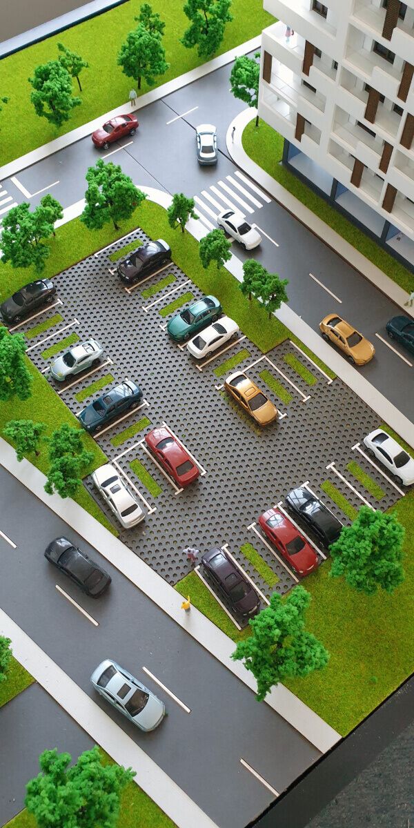 an aerial view of a parking lot with cars parked in it and trees on both sides