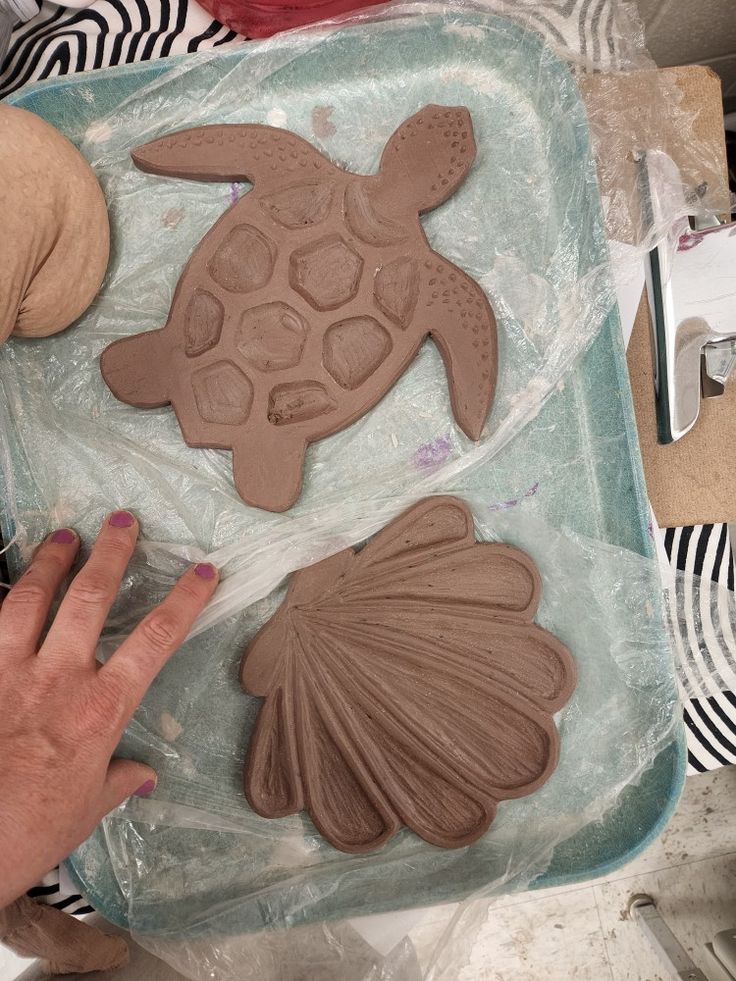 a person making clay sea animals on a table