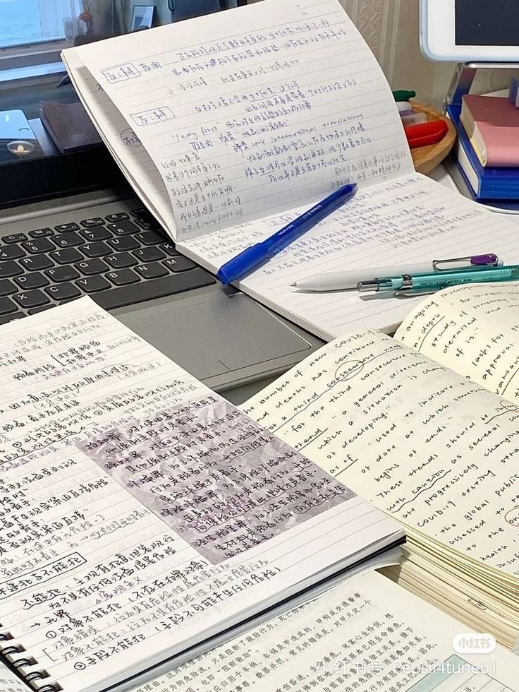 an open notebook sitting on top of a desk next to a laptop computer and keyboard