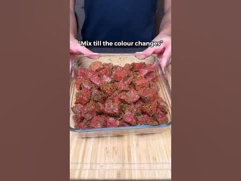 a person holding a tray full of meatballs in front of the camera text reads mix till the colours changes