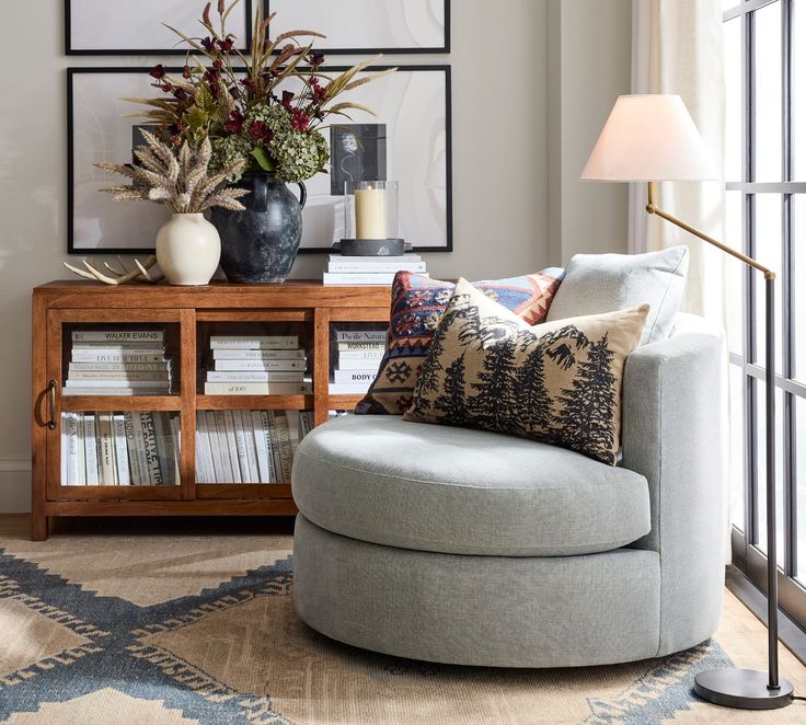 a living room filled with furniture and a tall vase on top of a wooden table