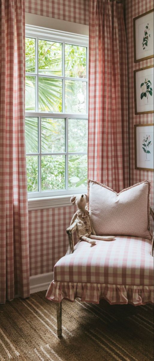 a chair sitting in front of a window with curtains on both sides and a teddy bear at the end