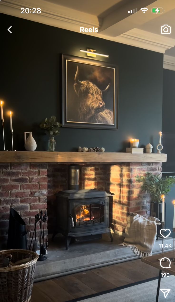 a living room with a fire place next to a painting on the wall and candles in front of it