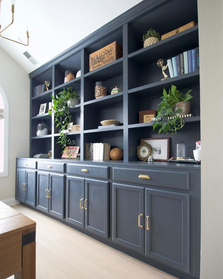 a blue bookcase with plants and books on it