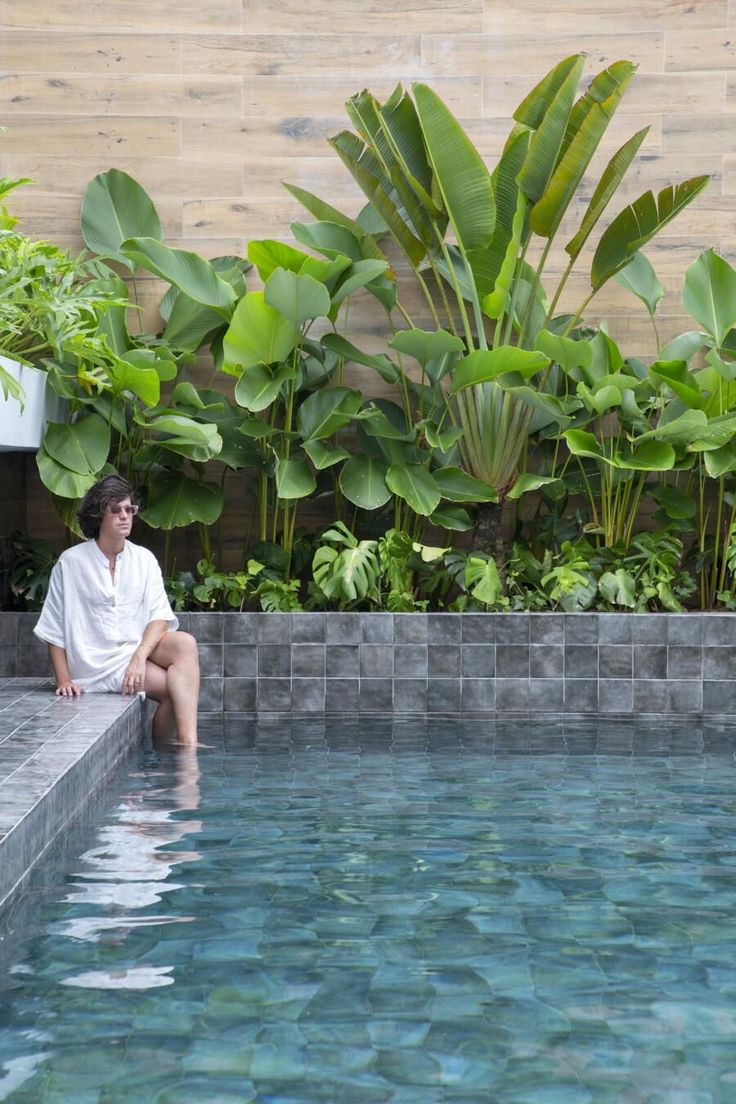 an outdoor swimming pool surrounded by greenery